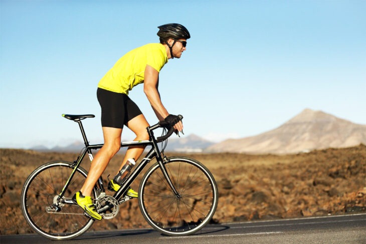 Rennradfahrer mit Rennrad bergauf